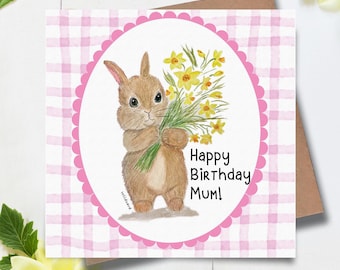 May include: A birthday card with a watercolour illustration of a brown rabbit holding yellow daffodils. The card has a pink scalloped border and a pink and white gingham pattern. Text reads "Happy Birthday Mum!"