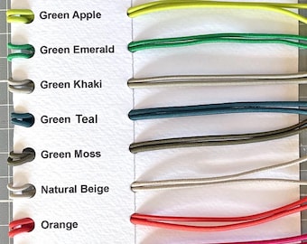 May include: A color chart featuring seventeen elastic cords in various shades including black, blue aqua, blue marine, blue sapphire, burgundy, gold bling, green apple, green emerald, green khaki, green teal, green moss, natural beige, orange, pink, purple, red, sand, and yellow.