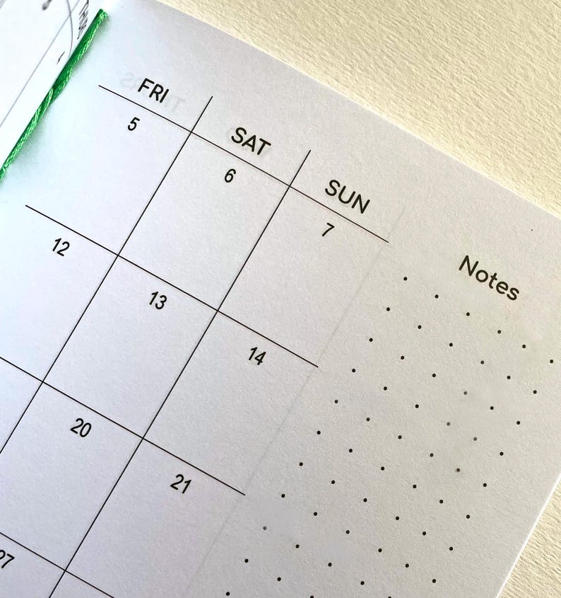 May include: A white paper planner page featuring a grid calendar layout with black text for the days FRI, SAT, and SUN, numbered dates 5 through 21, and a dedicated column on the right side labeled Notes with a black dot grid pattern.