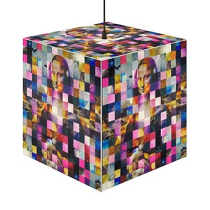 May include: Cube-shaped pendant lamp featuring a mosaic of the Mona Lisa portrait. The lamp's surface is a patchwork of colorful squares in shades of pink, blue, yellow, and black. A black cord extends from the top.