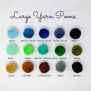 May include: A chart of large yarn pom poms in various colors, including aqua, bright blue, royal blue, dusty blue, navy, mint, neon green, bright green, kelly green, moss, gold, copper, cinnamon, gray, and black.