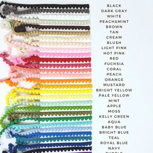 May include: A variety of pom pom trim in different colors, including black, white, peach, brown, tan, cream, blush, light pink, hot pink, red, fuchsia, coral, peach, orange, mustard, bright yellow, pale yellow, mint, apple, moss, kelly green, aqua, baby blue, bright blue, teal, royal blue, navy, purple, lavender, orchid, and mauve.