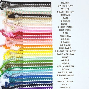 May include: A variety of pom pom trim in different colors, including black, dark gray, white, peach and mint, brown, tan, cream, blush, light pink, hot pink, red, fuchsia, coral, peach, orange, mustard, bright yellow, pale yellow, mint, apple, moss, kelly green, aqua, baby blue, bright blue, teal, royal blue, navy, purple, lavender, orchid, and mauve.