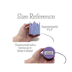 May include: A purple felt crown with a glittery top and a white felt bottom. The crown is approximately 3 inches by 3 inches. The crown is held in a hand and the bottom of the crown is visible. The crown is made by Little Blue Olive.