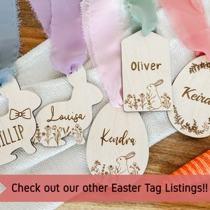 May include: Five wooden Easter tags with different designs. The tags are decorated with bunnies, flowers, and the names Phillip, Louisa, Kendra, Oliver, and Keira. The tags are tied with ribbons in various colours.
