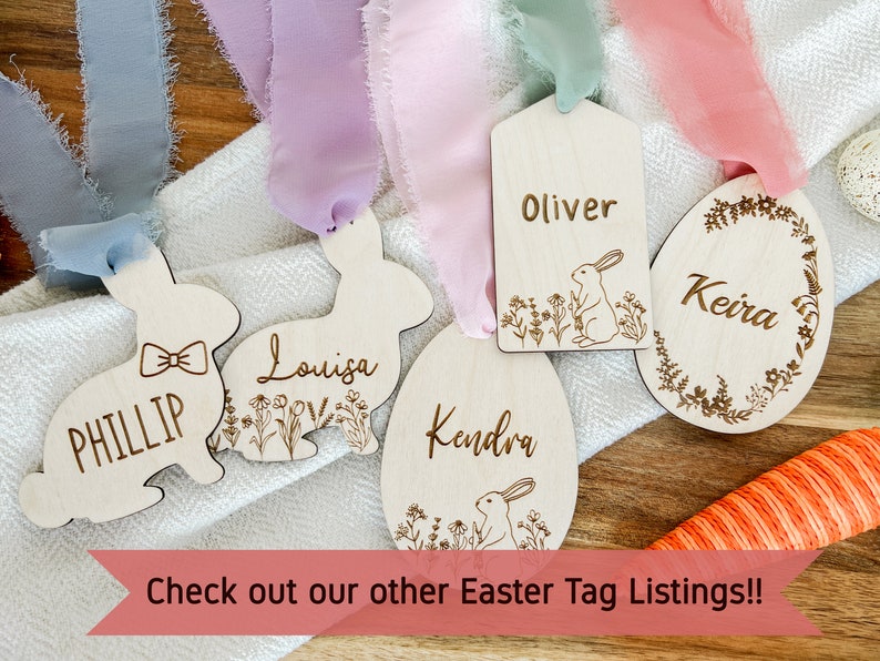 May include: Five wooden Easter tags with different designs. The tags are decorated with bunnies, flowers, and the names Phillip, Louisa, Kendra, Oliver, and Keira. The tags are tied with ribbons in various colours.