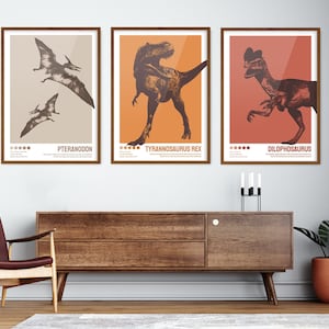 May include: Three framed illustrations of dinosaurs. The first illustration is of a Pteranodon, the second is of a Tyrannosaurus Rex, and the third is of a Dilophosaurus. The illustrations are in a vintage style with brown and orange colours.