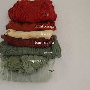 Può includere: Un set di sette campioni di tessuto in varie tonalità di rosso, arancione, giallo, marrone e verde. I campioni sono etichettati con i seguenti nomi: Fire, burnt orange, honey, burnt sienna, grass, asparagus e sage.