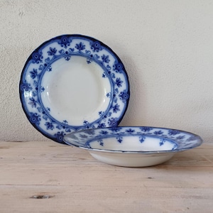May include: Two blue and white ceramic bowls with a floral design. The bowls are stacked on top of each other.