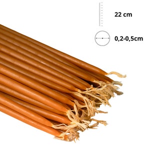 Könnte beinhalten: Ein Bündel aus 22 cm langen, braunen Bienenwachs-Kerzen, jede mit einem Durchmesser von 0,2-0,5 cm. Die Kerzen sind gebündelt und haben ein natürliches, rustikales Aussehen.