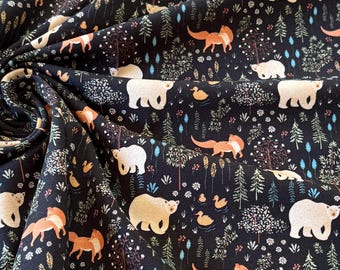 May include: Dark fabric with a repeating pattern of white bears, orange foxes, ducks, and trees. The design includes various types of foliage and small flowers, all set against a black background. The fabric is folded, showing its texture.