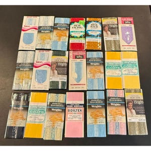Könnte beinhalten: Eine Sammlung von Vintage-Nähzubehör, darunter Nahtband, Saumband und Rick Rack. Die Verpackungen zeigen verschiedene Farben und Marken wie Wrights, Talon und Boiltex. Jede Packung ist etwa 2,74 Meter lang.