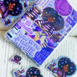 May include: Purple phone case and stickers featuring a Black woman with curly hair, glasses, and butterflies. The case has text that reads "Spiritually, I am at the bookstore" and "Read to me & tell me I'm pretty."