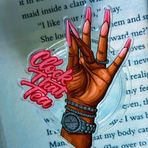 Könnte beinhalten: Ein klarer Aufkleber mit einer braunen Hand mit langen, rosa Nägeln, die eine diamantbesetzte Uhr und Armbänder trägt. Der Aufkleber hat den Text "Clock That Tea" in rosa Buchstaben. Ein Ring ist zu sehen.