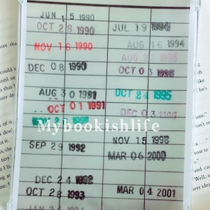 May include: A clear plastic card holder with a grid of dates and a "DATE DUE" label. The dates are filled in with handwritten numbers and years, ranging from 1990 to 2001.