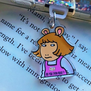 May include: A clear acrylic keyring featuring a cartoon character with orange hair and a pink outfit. The character has a skeptical expression and the text "DO YOU EVEN READ?" is printed on the outfit. The keyring is attached to a phone case.