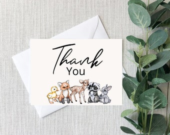 May include: A white thank you card with black text that says "Thank You". The card features a cartoon illustration of a fox, deer, raccoon, and rabbit.