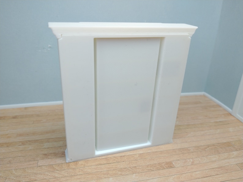 May include: White painted wooden fireplace mantel with a rectangular opening. The mantel has a simple design with a flat top and a slightly raised base.