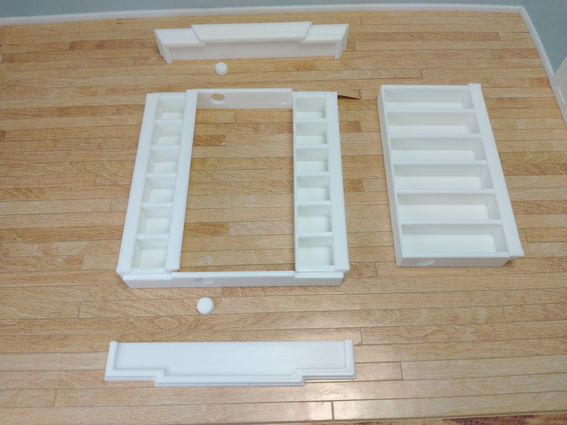 May include: White, unassembled, wooden shelf unit with multiple compartments. The shelf unit is made of several pieces that can be assembled to create a variety of configurations.