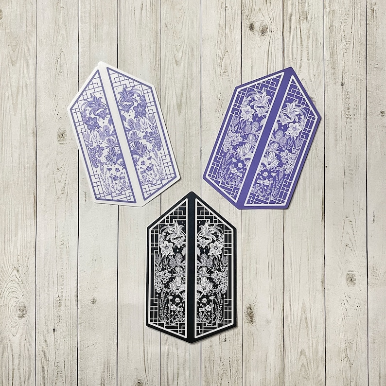 May include: Three decorative window pane designs with floral patterns. The designs are in shades of purple, black, and white.