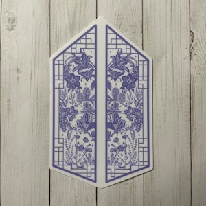 May include: A symmetrical design of a blue floral pattern inside a white frame with a geometric pattern. The design is split into two halves, with each half featuring a different arrangement of flowers and leaves. The design is reminiscent of a window or a door.