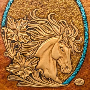 Peut inclure: Une œuvre d'art en cuir beige représentant une tête de cheval et une crinière flottante dans un cadre ovale. Le cadre est souligné de turquoise, et le fond a un aspect doré texturé. Des éléments floraux sont sculptés autour du cheval.