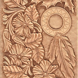 May include: A brown leather carving with a floral design, a sunburst, and a feather. The carving is signed "Jimpa" in the bottom right corner.