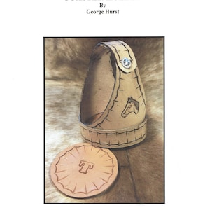 May include: A leather coaster holder with a horse design and a matching coaster. The holder is brown and has a decorative stitch pattern. The coaster is round and has a simple design.