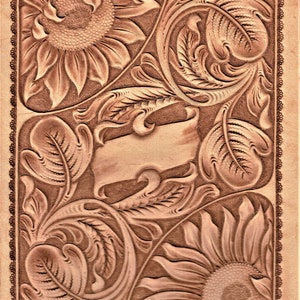 Op de afbeelding: Een bruine lederen achtergrond met een gegraveerd ontwerp van zonnebloemen en scrollende bladeren. Het ontwerp is lichtbruin van kleur en heeft een reliëf.
