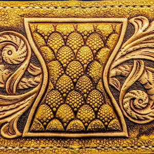 May include: A brown leather wallet with a tooled design featuring a floral pattern and a geometric pattern in the centre. The wallet has a stitched border.