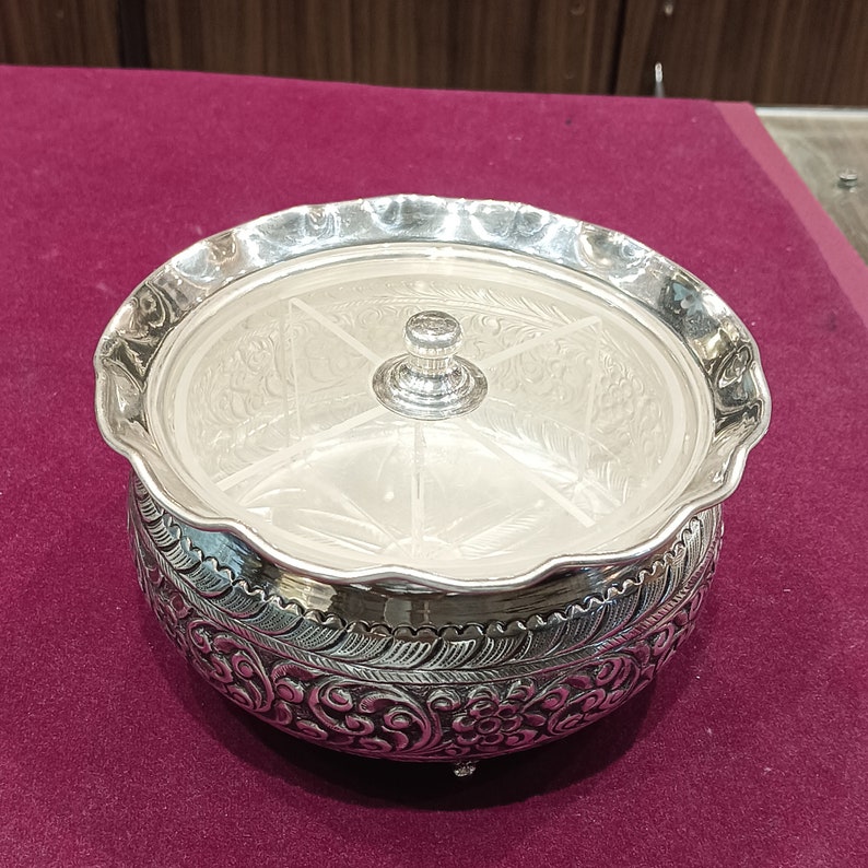 May include: A silver serving dish with a lid and four compartments. The dish is decorated with intricate floral designs.