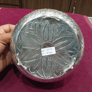 May include: Silver bowl with intricate floral designs and a label that reads "Wt: 3232  m: 8.8 gm".