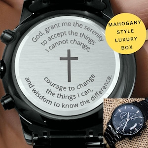 May include: Black wristwatch with a stainless steel face featuring a cross and inspirational text. The watch has a black metal band and a smaller image of the watch is visible. The watch is in a mahogany style luxury box.
