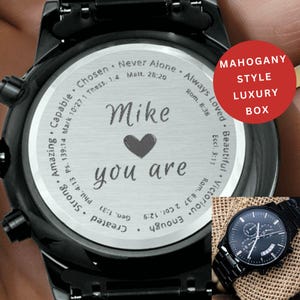 May include: Black wristwatch with a stainless steel back engraved with the words "Mike, you are" and a heart symbol. The watch has a black band and face. The watch is displayed with a "Mahogany Style Luxury Box".