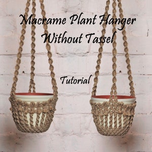May include: A macrame plant hanger without a tassel, made with natural jute rope, hanging from a white brick wall. The hanger is designed to hold a small plant pot.