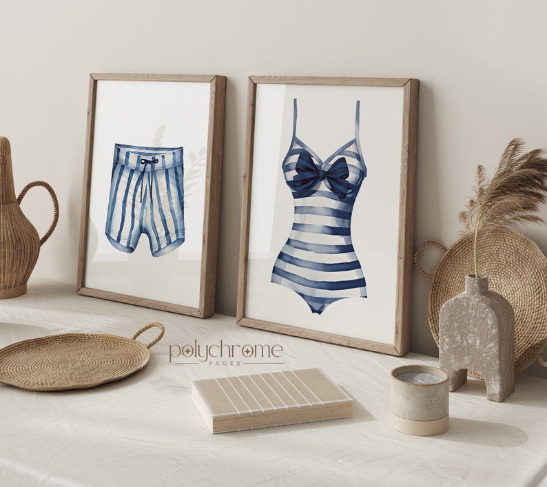 Pode incluir: Duas impress&otilde;es emolduradas de ilustra&ccedil;&otilde;es de aquarela de roupas de banho listradas. A impress&atilde;o &agrave; esquerda mostra uma sunga listrada azul e branca. A impress&atilde;o &agrave; direita mostra um mai&ocirc; listrado azul e branco com um la&ccedil;o azul.