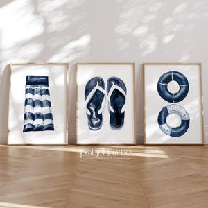 May include: Three framed prints with a nautical theme. The first print features a blue and white striped inflatable raft. The second print features a pair of blue flip flops. The third print features two blue and white life preservers.