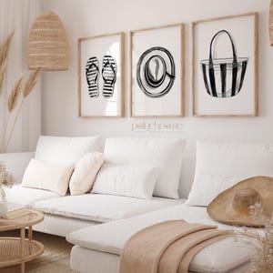 Puede incluir: Tres ilustraciones en blanco y negro en marcos sobre una pared blanca. Las ilustraciones son de un par de chanclas, un sombrero de sol y una bolsa de playa a rayas.