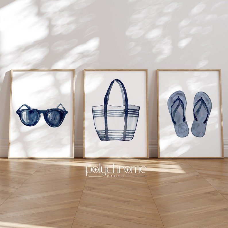 May include: Three framed prints with a nautical theme. The first print features a pair of blue sunglasses. The second print features a blue and white striped tote bag. The third print features a pair of blue flip flops.