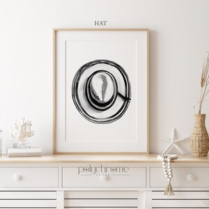 Puede incluir: Impresi&oacute;n de arte abstracto en blanco y negro de un c&iacute;rculo con anillos conc&eacute;ntricos. La impresi&oacute;n est&aacute; enmarcada y colgada en una pared blanca. El texto "HAT" est&aacute; escrito encima de la impresi&oacute;n.