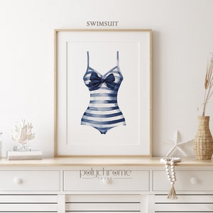 Pode incluir: Uma ilustra&ccedil;&atilde;o em aquarela de um mai&ocirc; listrado azul e branco com um la&ccedil;o azul. A ilustra&ccedil;&atilde;o &eacute; emoldurada e exibida em uma prateleira branca.