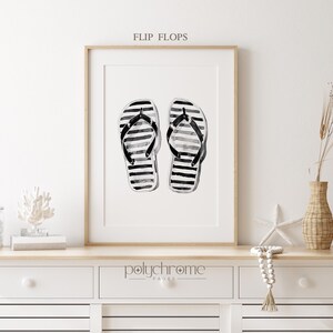 Puede incluir: Ilustraci&oacute;n acuarela en blanco y negro de un par de chanclas con un patr&oacute;n a rayas. La imagen est&aacute; enmarcada y titulada "Flip Flops".