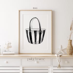 Puede incluir: Bolso tote de rayas blancas y negras con asas negras. El bolso est&aacute; dibujado en un estilo minimalista y est&aacute; enmarcado en un marco de madera. El texto "BAG" est&aacute; por encima del marco y el texto "polychrome pages" est&aacute; por debajo del marco.