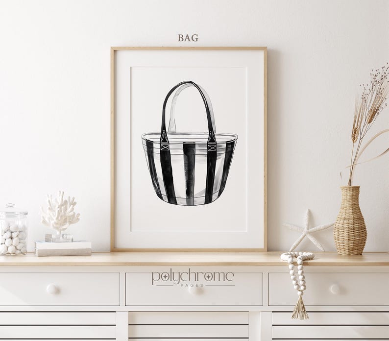 Puede incluir: Bolso tote de rayas blancas y negras con asas negras. El bolso est&aacute; dibujado en un estilo minimalista y est&aacute; enmarcado en un marco de madera. El texto "BAG" est&aacute; por encima del marco y el texto "polychrome pages" est&aacute; por debajo del marco.