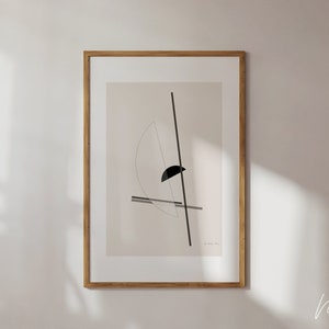 May include: A framed abstract art print with a black and white geometric design on a beige background. The print is in a light wood frame.