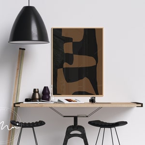 May include: A minimalist home office with a wooden desk, two black metal bar stools, and a framed abstract print with brown and black geometric shapes.