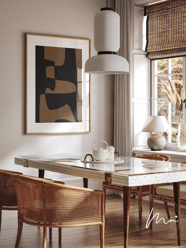 May include: A dining room with a white table with a marble top and a white pendant light hanging above it. Two wicker chairs are placed on either side of the table. A framed abstract print hangs on the wall behind the table.