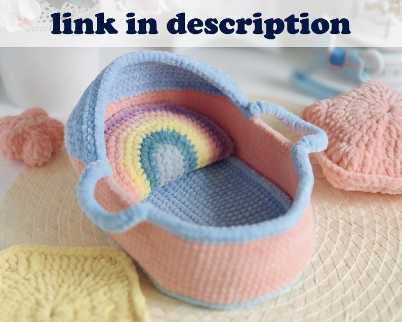 Pu&ograve; includere: Una culla per neonati in crochet rosa e blu con un cuscino in crochet arcobaleno all'interno. La culla &egrave; realizzata in filato morbido e ha un manico su ogni lato.