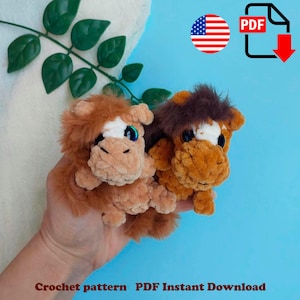 May include: Two handmade crochet horse plushies in shades of brown and tan, with white and blue accents. The plushies have fluffy manes and are held in a hand. The image includes a PDF download icon and the American flag.