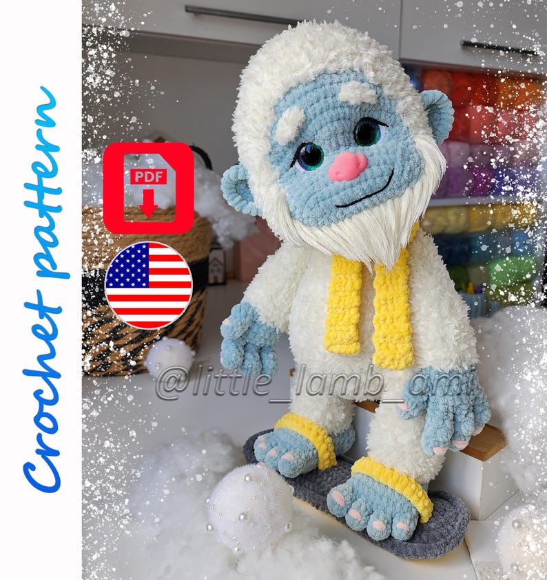 A plush crochet yeti with fluffy white fur, a light blue face, large sparkling eyes, and a pink nose wears a yellow scarf and gray slippers. The cover includes "Crochet pattern," a PDF download icon, and an American flag.